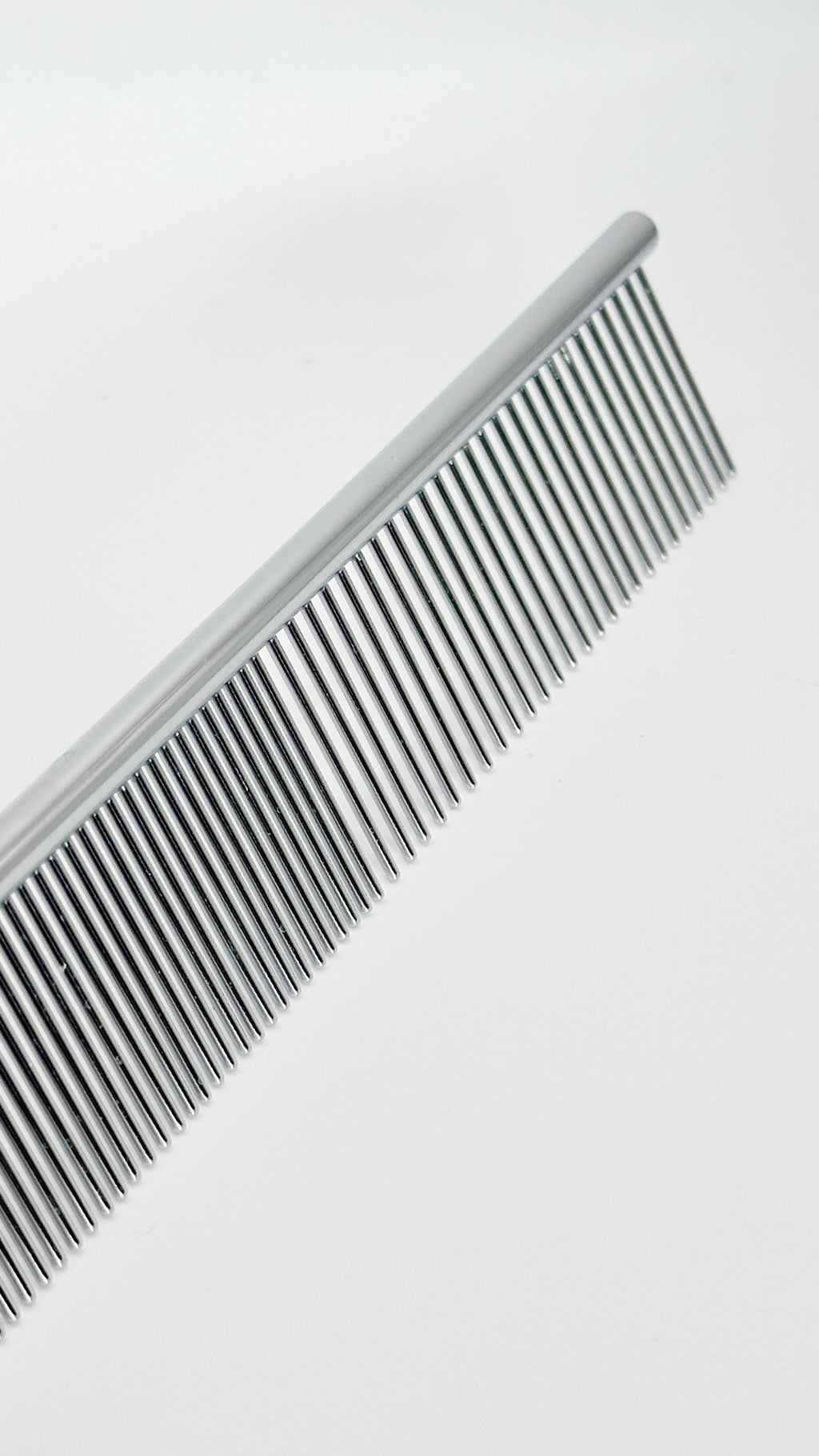 Close-up of NorrGroom 7.5 inch grooming comb showing fine and coarse stainless-steel teeth

