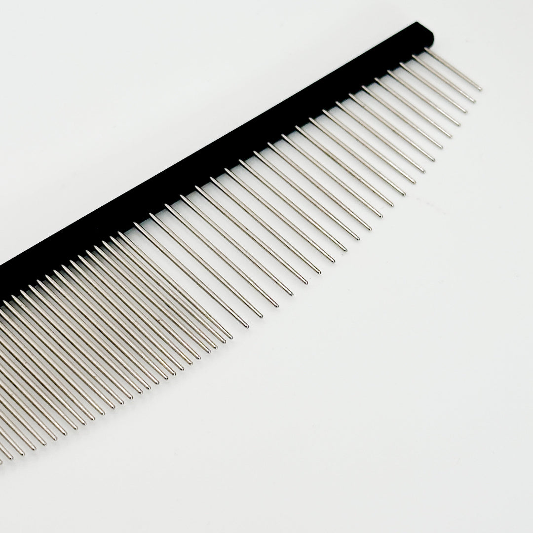 Professional groomer using NorrGroom 6.5 inch coarse/fine comb to finish a dog’s coat